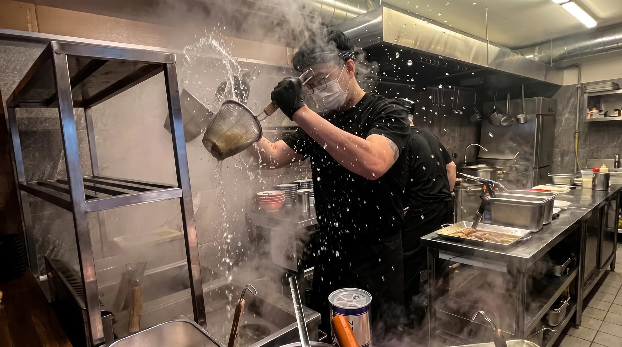 끓는 물에서 건져 올린 면의 물기를 터는 멘노아지 주방